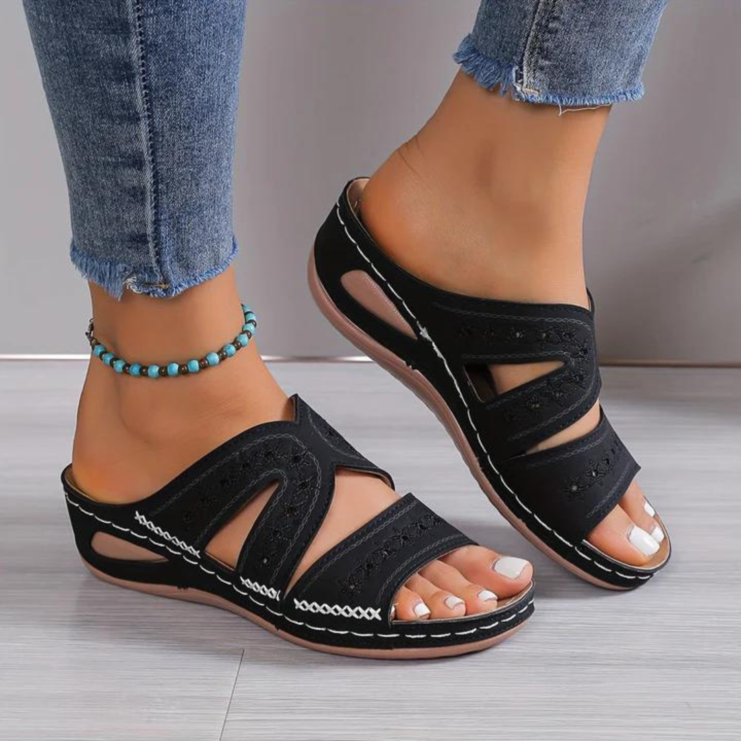 Women’s cutout wedge sandals in black with crisscross strap cutouts and stitched edging
