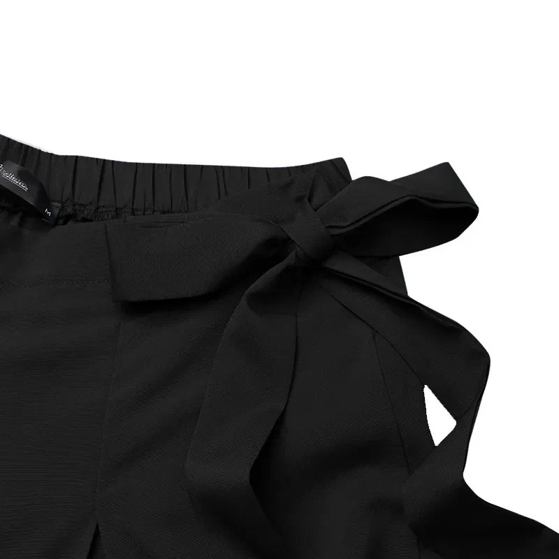 Black high-waisted trousers with gathered waist and side bow tie detail
