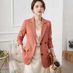 Women’s tailored blazer worn, coral pink double-breasted style with notched lapels and cuffs