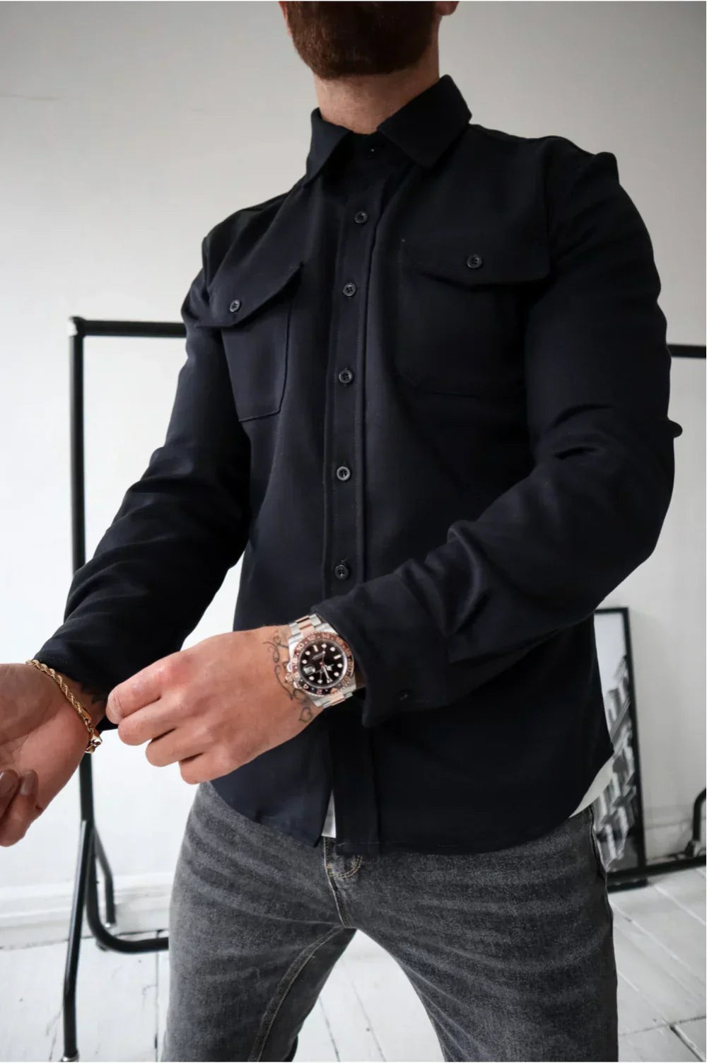 Black men’s button-front overshirt with two flap chest pockets and long sleeves