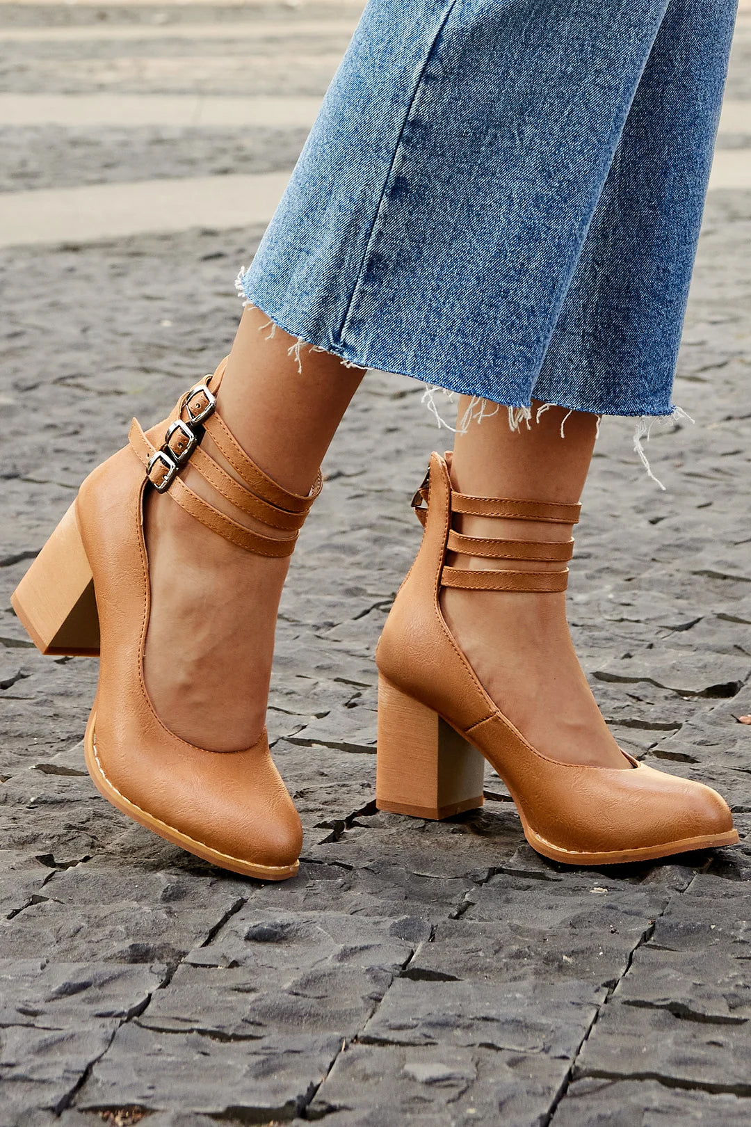 Brown triple-buckle block heel ankle strap pumps with stacked straps and square toe.