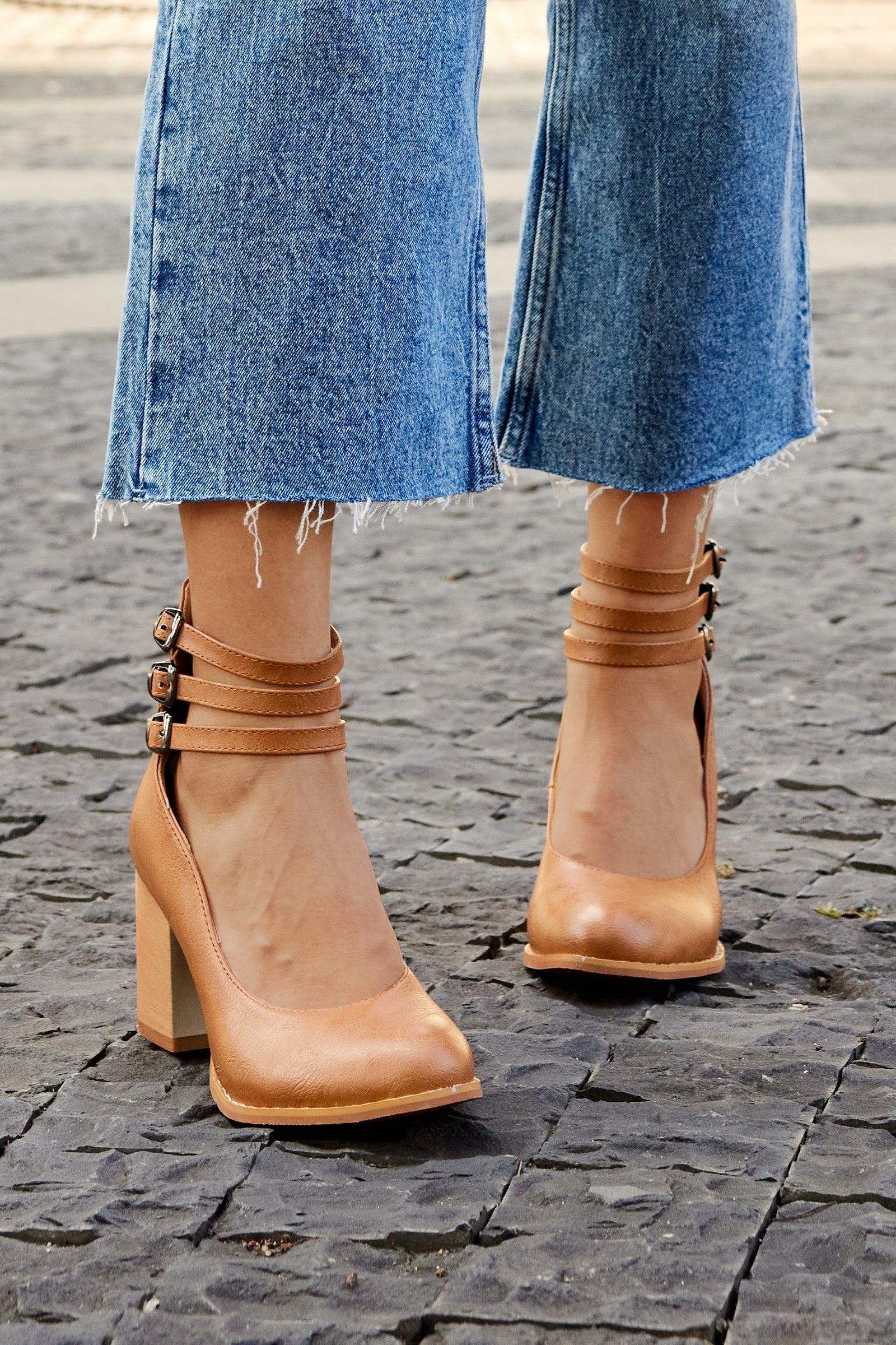 Brown triple-buckle block heel ankle strap pumps, side view with three buckle bands.