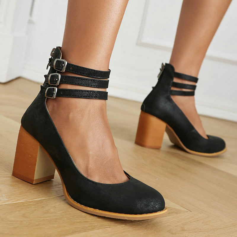 Black triple-buckle block heel ankle strap pumps with square toe and wooden block heel.