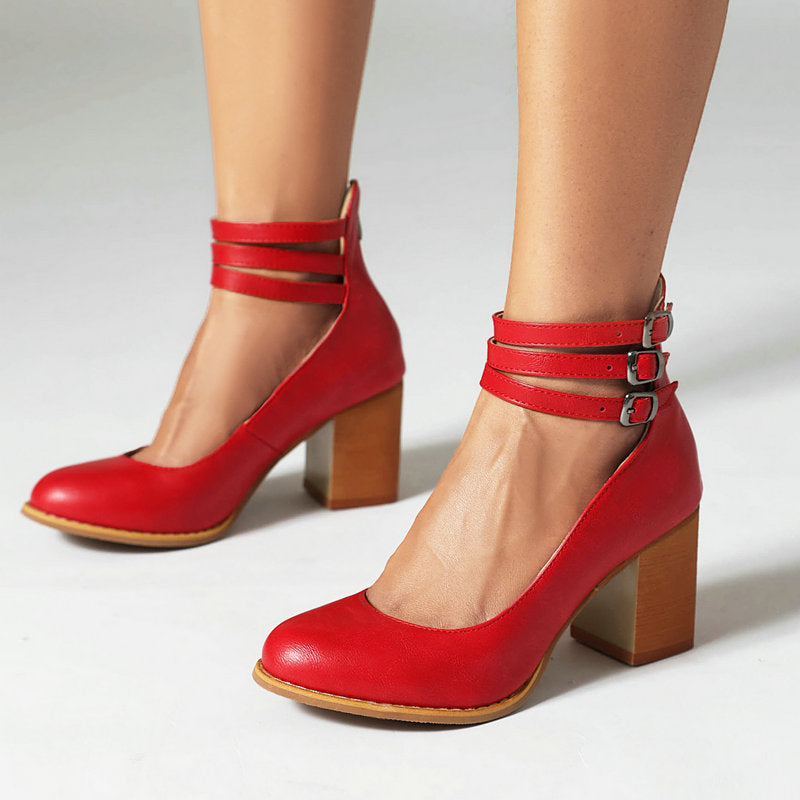 Red triple-buckle block heel ankle strap pumps with three strap bands and buckles.
