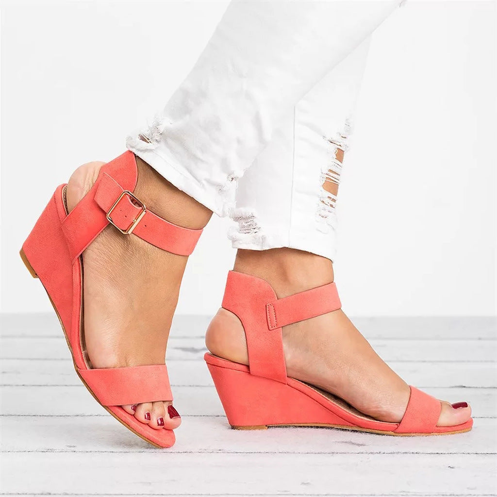 Women's coral wedge sandals, open toe with adjustable ankle strap, side view.