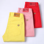 Folded men's casual pants: red, pink, and yellow with branded waistband label