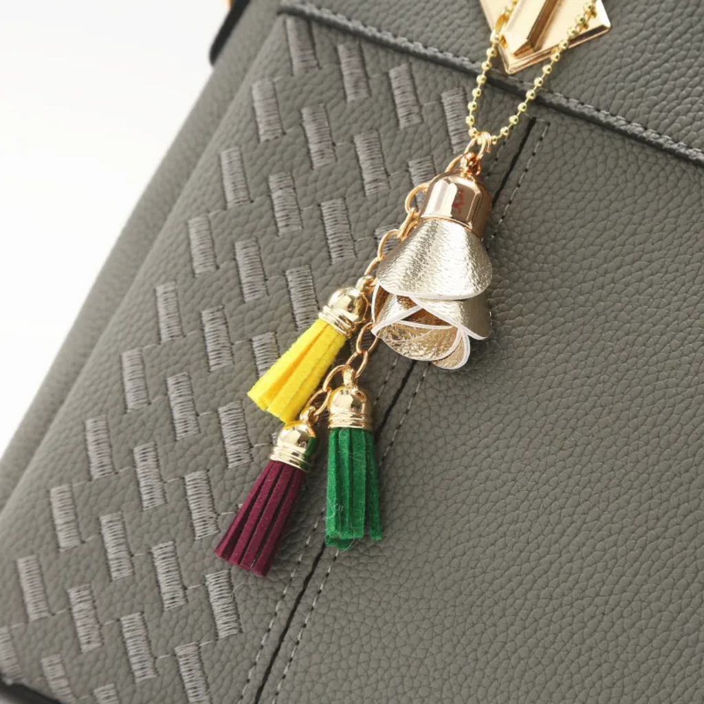 Gray textured shoulder bag with tassel charm and gold-tone clasp detail