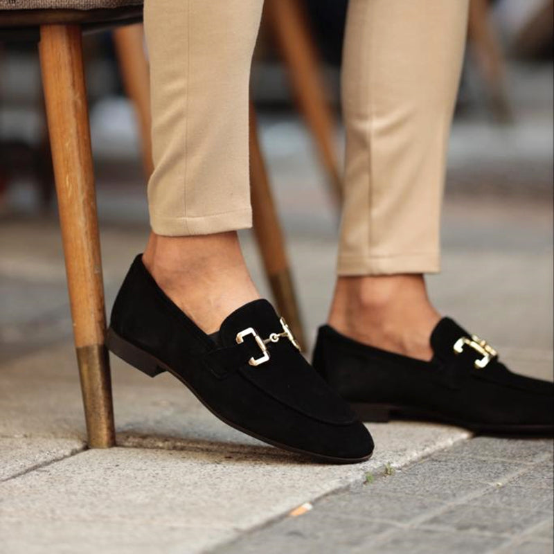 Black suede slip-on loafers with horsebit hardware and low heel