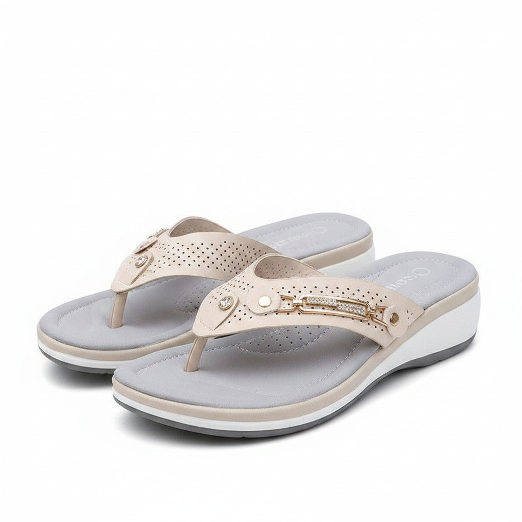 White women's slide sandals with perforated straps and gold chain ankle detail