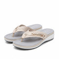 White women's slide sandals with perforated straps and gold chain ankle detail