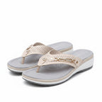 White women's slide sandals with perforated straps and gold chain ankle detail
