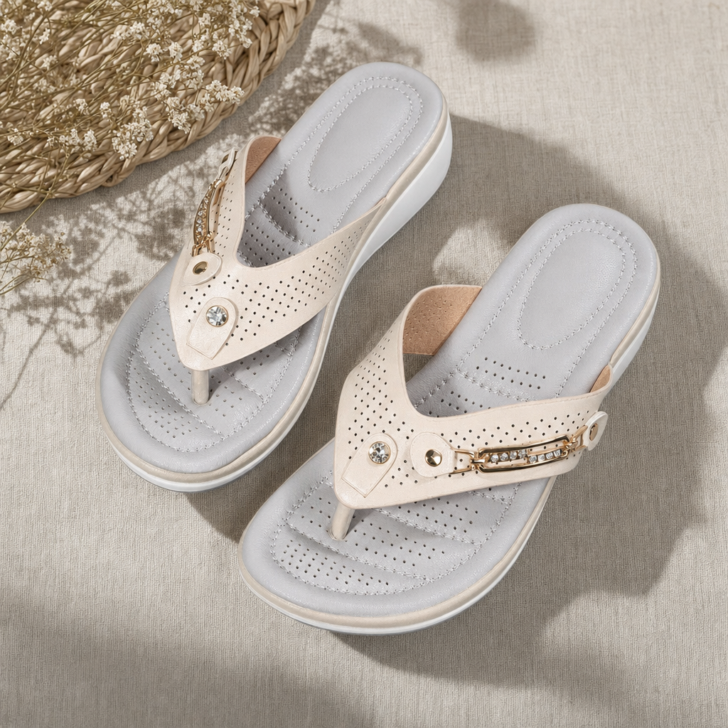 Pair of white women's orthopedic thong sandals with perforated uppers and buckle detail