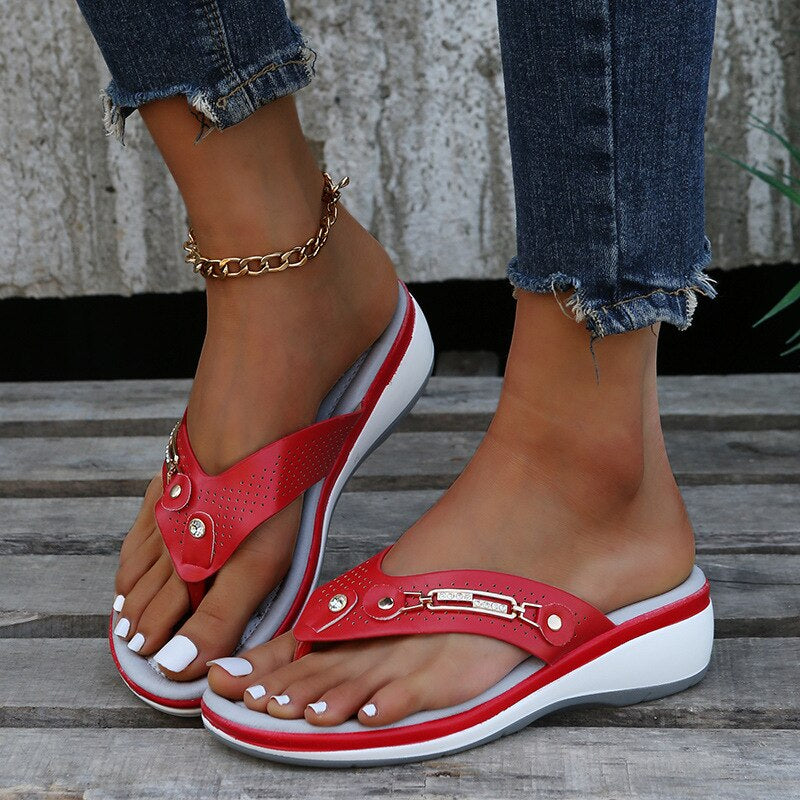 Red women's slide sandals with perforated straps and gold-tone buckle detail