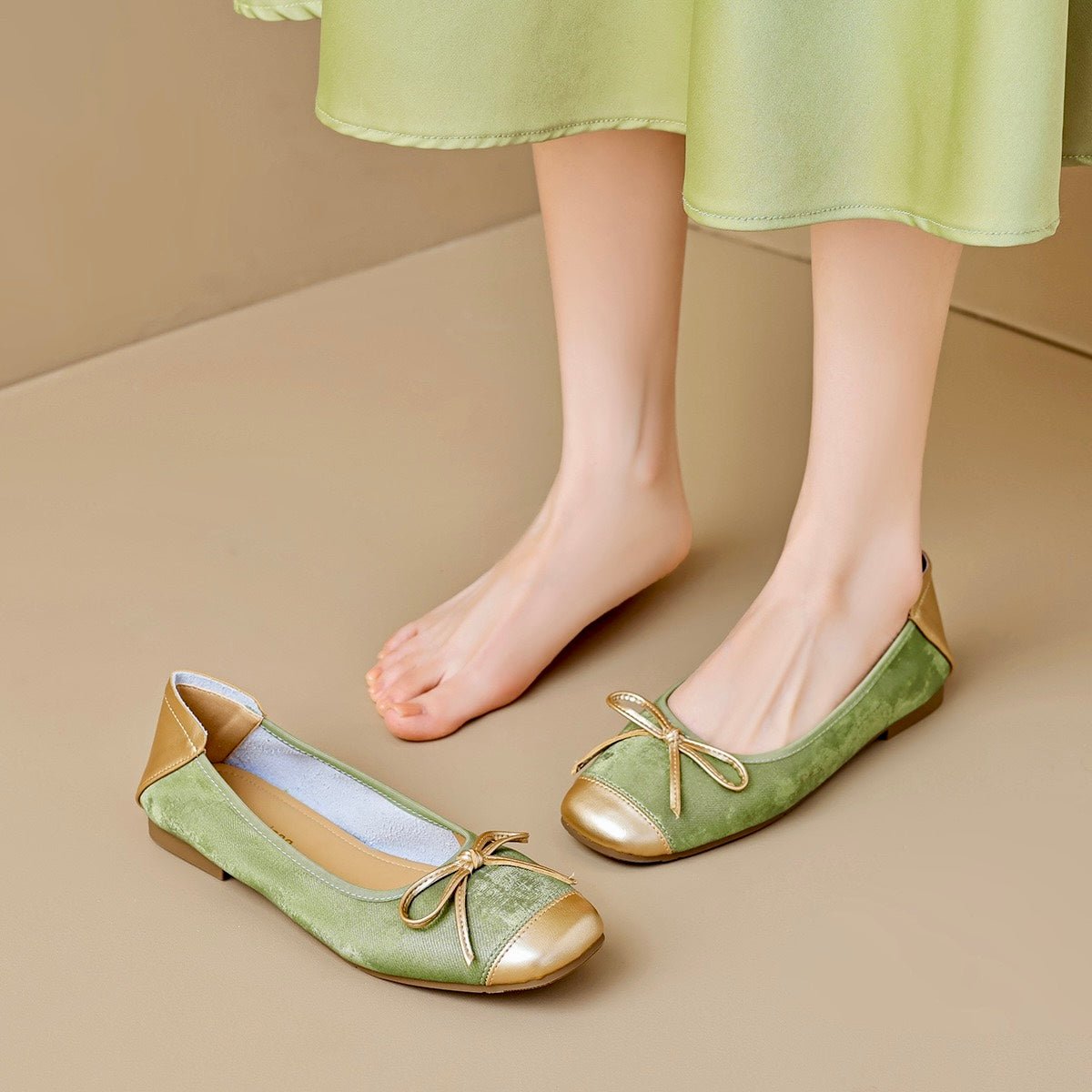 Metallic olive square-toe ballet flats with gold toe cap and bow ties worn