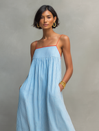 Blue striped maxi dress with spaghetti straps, gathered bodice, and contrast red edge