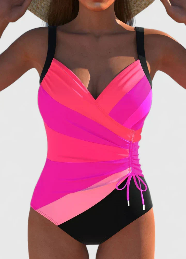 One-piece wrap swimsuit with bright pink top panel, black base, and side tie