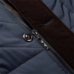 Blue quilted jacket zipper detail with metal pull and contrast stitched trim