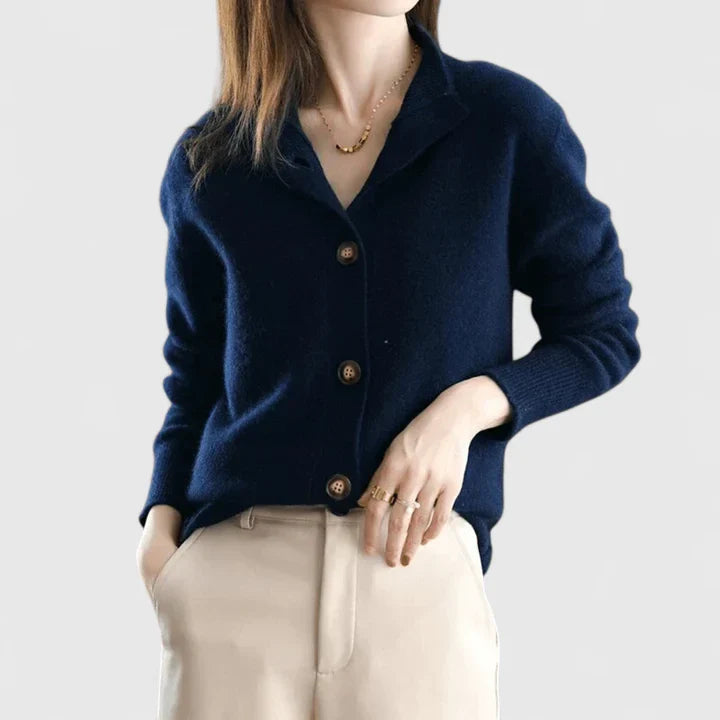 Dark blue knit cardigan with button front, long sleeves, and ribbed cuffs.