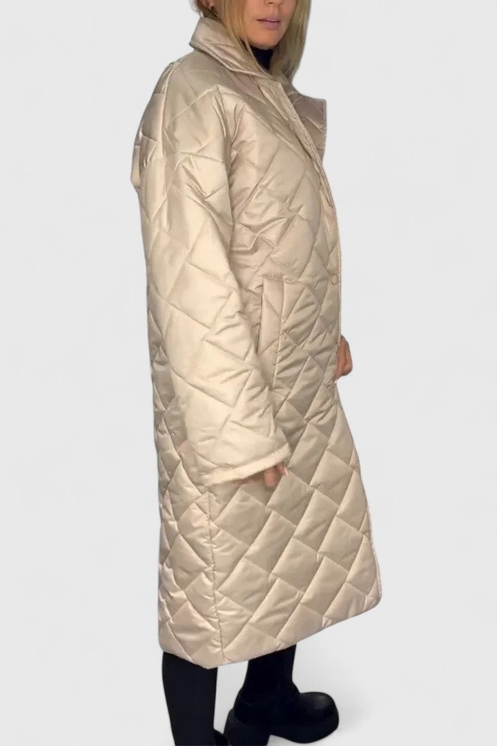 Long beige quilted coat with button front and high neck, side pockets