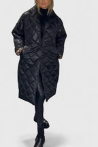 Long black quilted coat with button front, notch collar, and side pockets