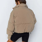 Beige puffer jacket back view with hood and ribbed cuff details