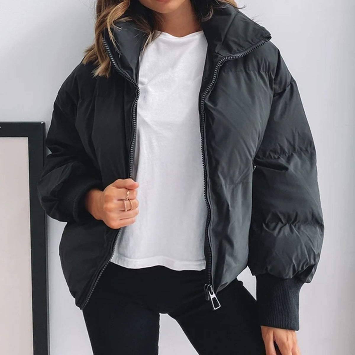 Black cropped puffer jacket with full zip, hood, and ribbed cuffs