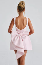 Back view of blush pink sleeveless mini dress with pearl trim and bow detail