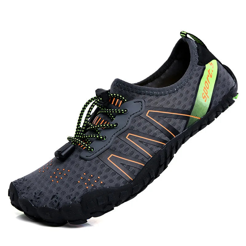 Unisex waterproof barefoot water shoe in dark gray/black with green laces and orange accents