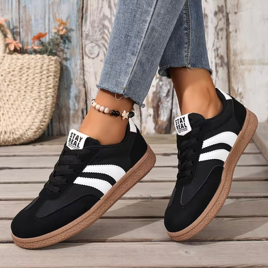 Women’s comfort lace-up sneakers in black with white stripes and gum sole