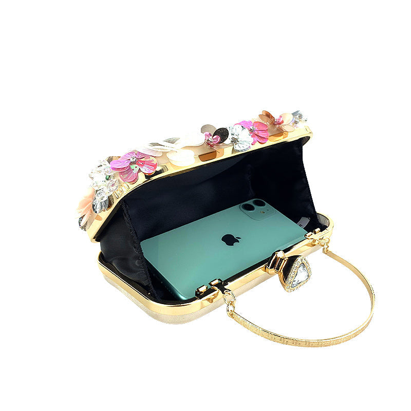 Open floral clutch bag with black lining, gold-tone clasp, and gold chain handle