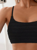 Black textured bikini top with thin spaghetti straps, side view