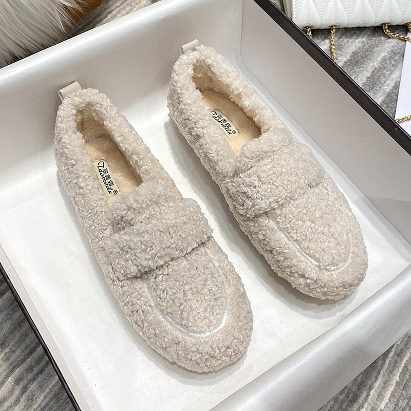 Pair of women’s cream fleece teddy slip-on slippers in a box