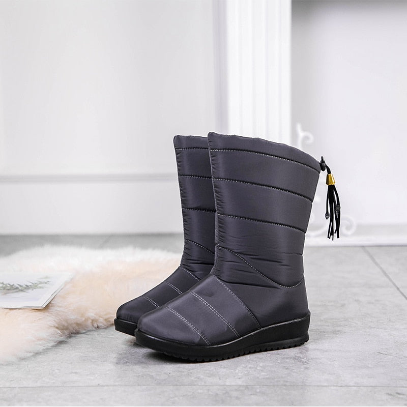 Dark grey mid-calf winter boots with quilted side panels, tassel pull, and rubber sole
