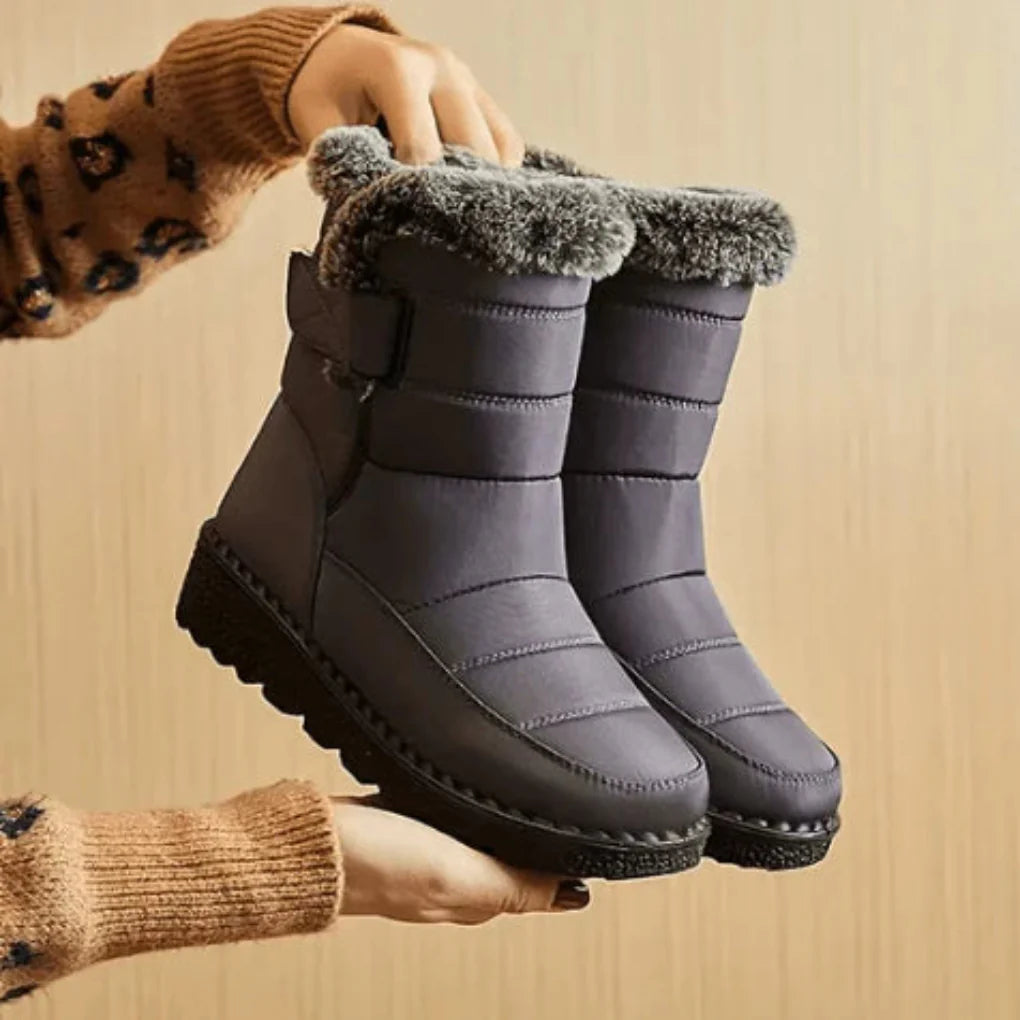 Women’s waterproof snow boots in dark grey with faux-fur trim and side buckle detail