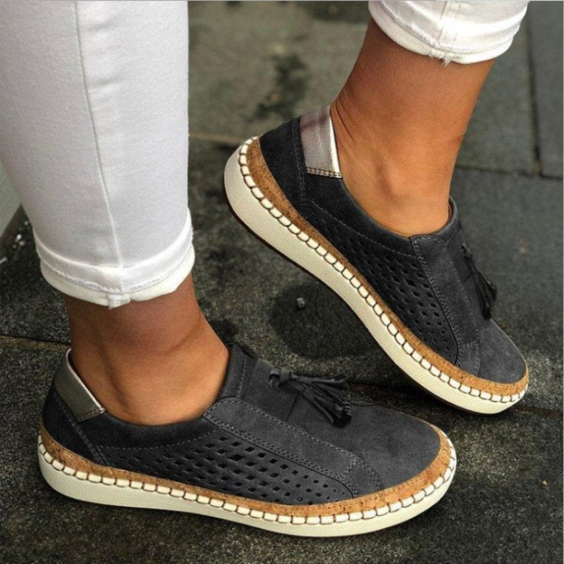 Women's slip-on walking shoes, black perforated uppers with tassel detail