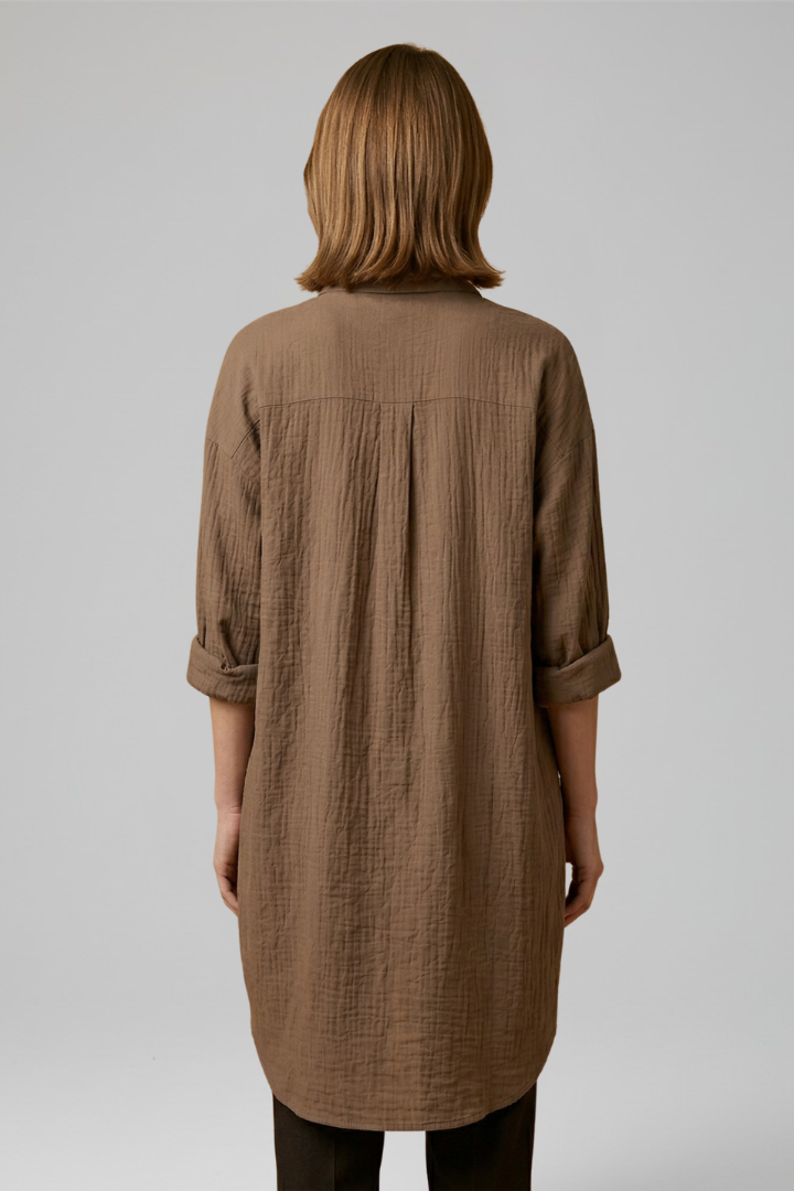 Brown women’s blouse, back view with yoke seam and buttoned cuffs, three-quarter sleeves.
