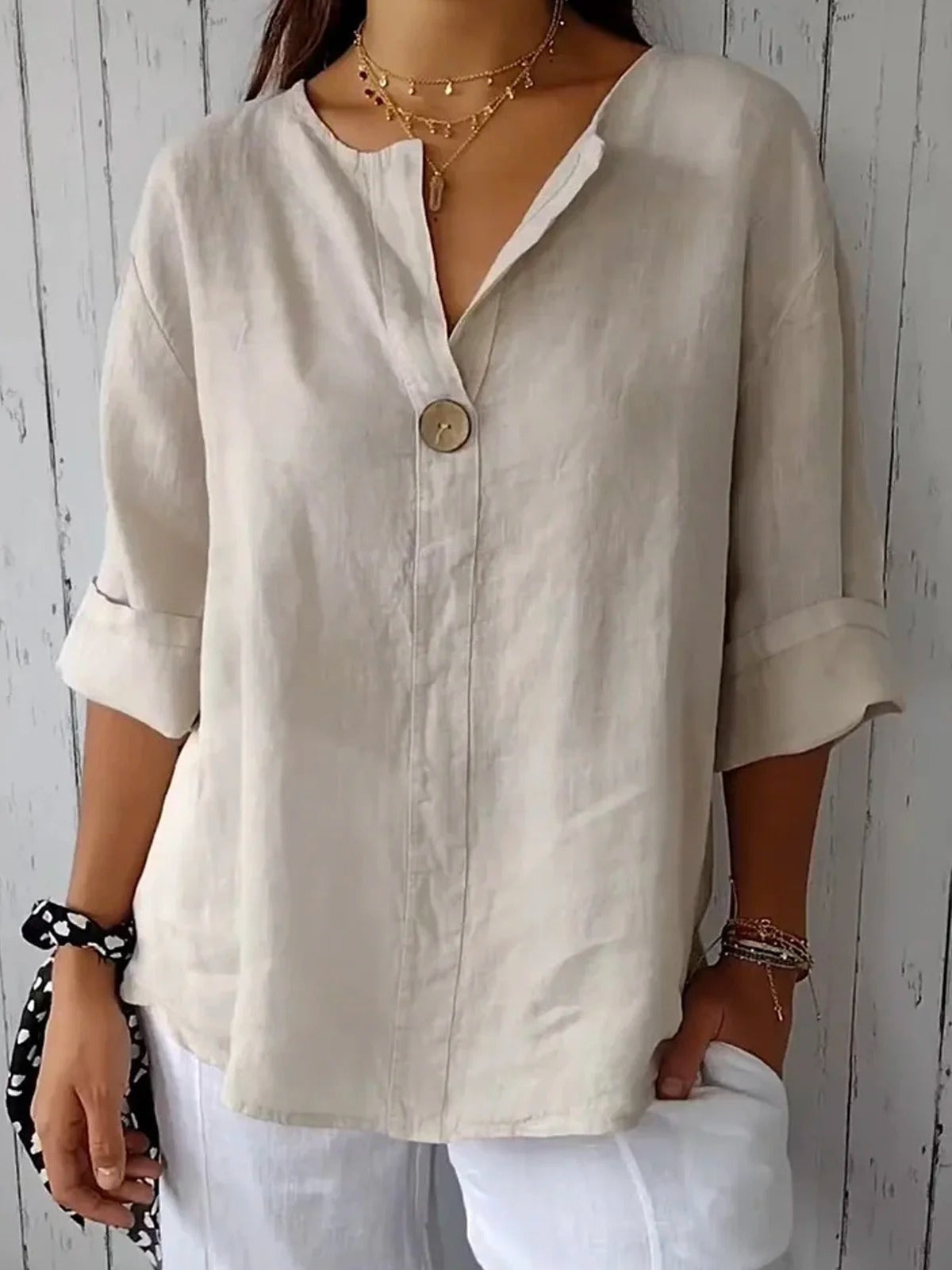 Beige/white cotton V-neck blouse with single front button and three-quarter sleeves