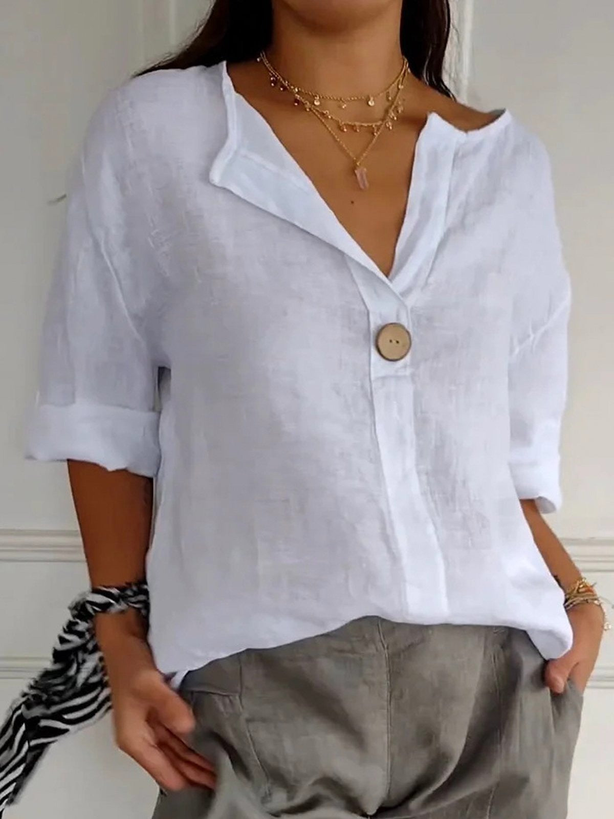 White cotton V-neck blouse with single front button and three-quarter sleeves