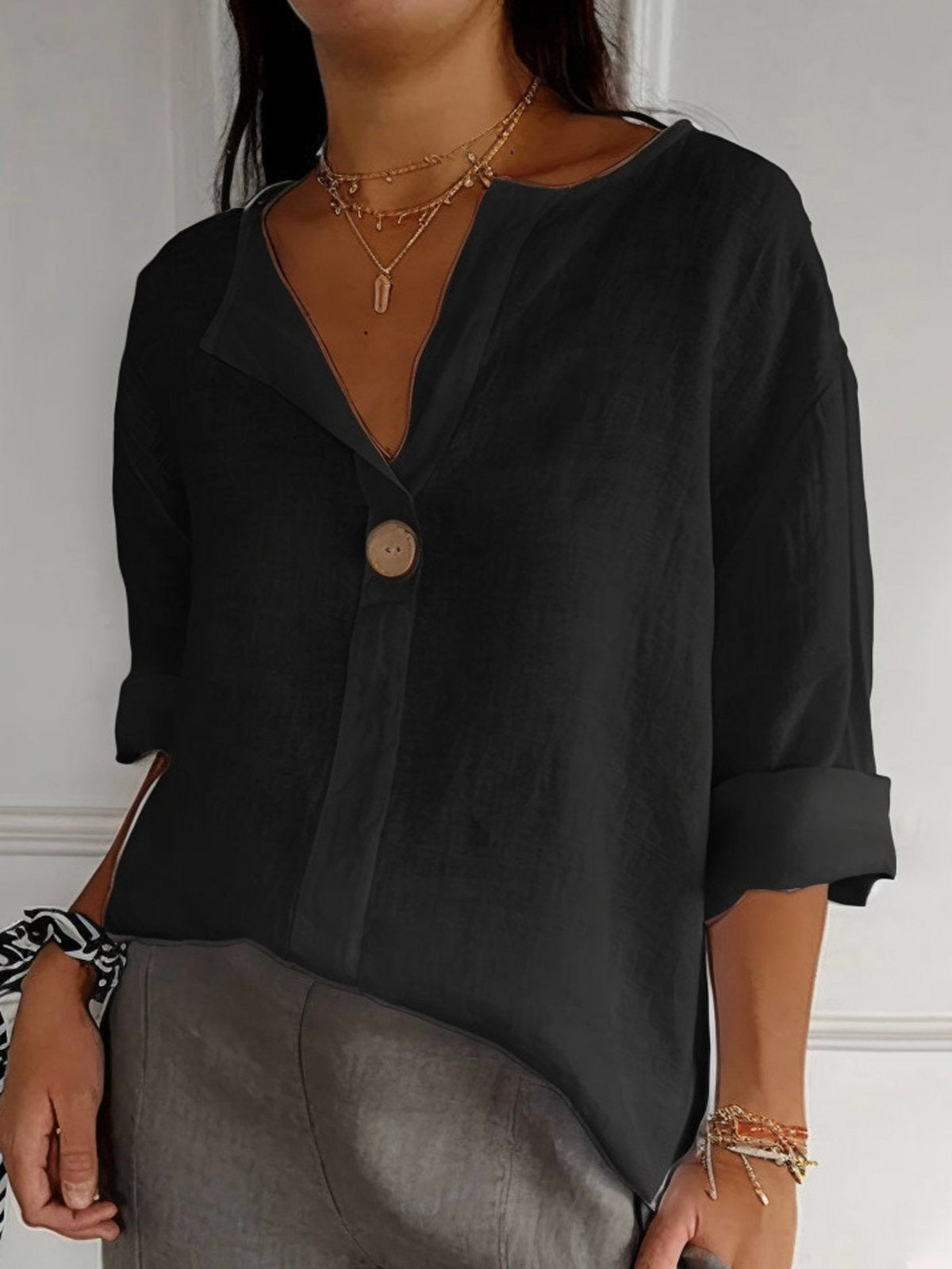 Black cotton V-neck blouse with single front button and three-quarter sleeves