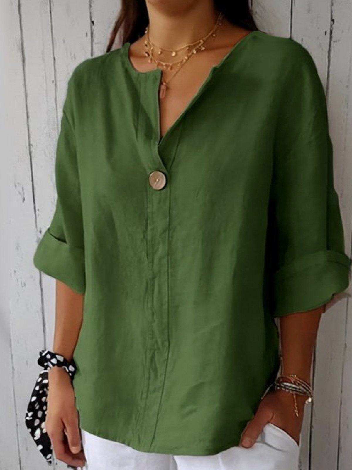 Green cotton V-neck blouse with single front button and three-quarter sleeves