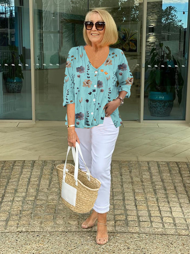 Women’s teal floral V-neck blouse with 3/4 sleeves and button-front placket