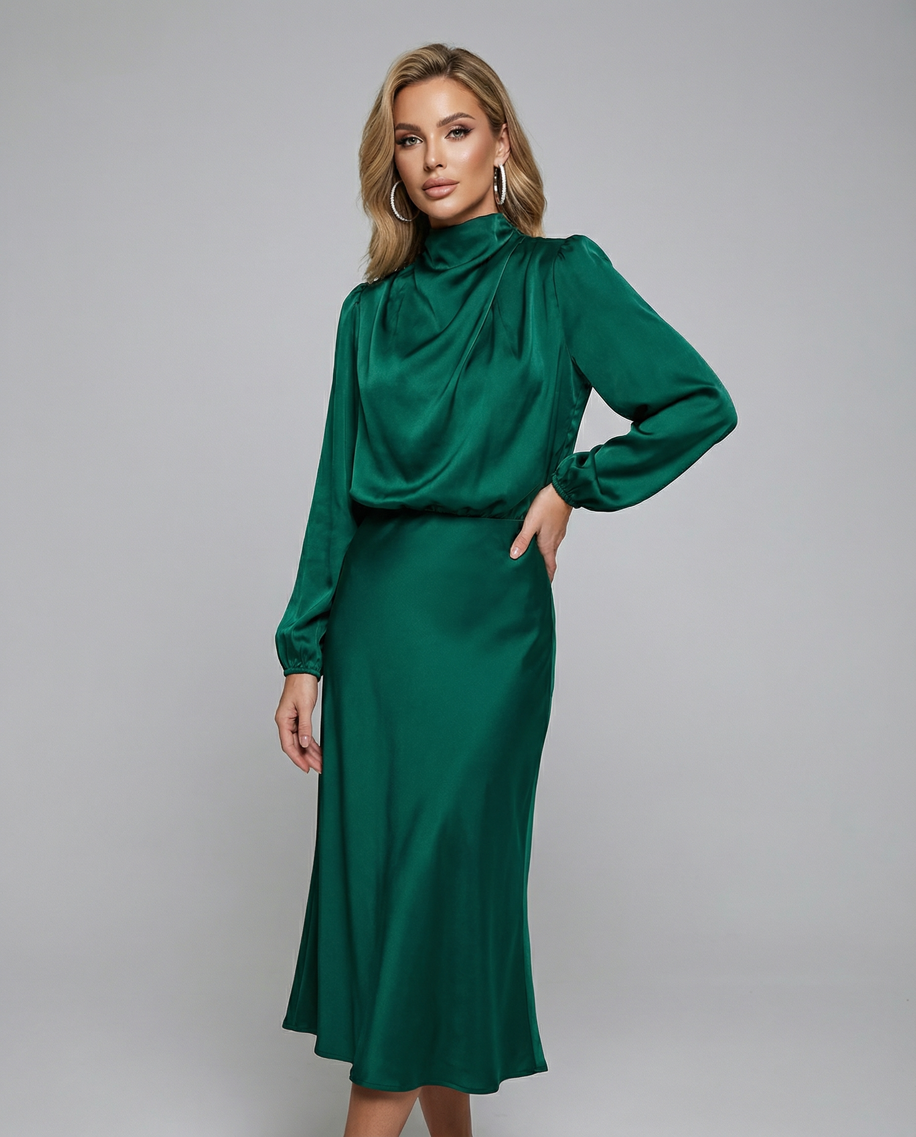 Dark green satin midi dress with long sleeves and high neck, one hand on hip.