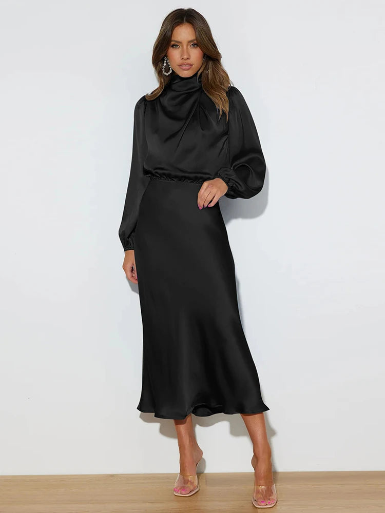 Black satin midi dress with long sleeves and high neck, side standing view.