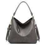 Large crossbody zip bag in gray with adjustable strap, top zipper, and zip compartments