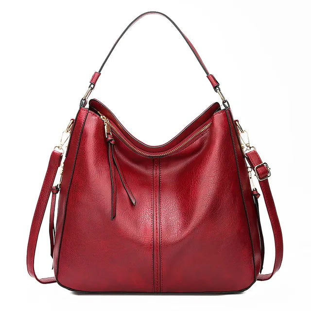 Large crossbody zip bag in red with adjustable strap, top zipper, and zip compartments