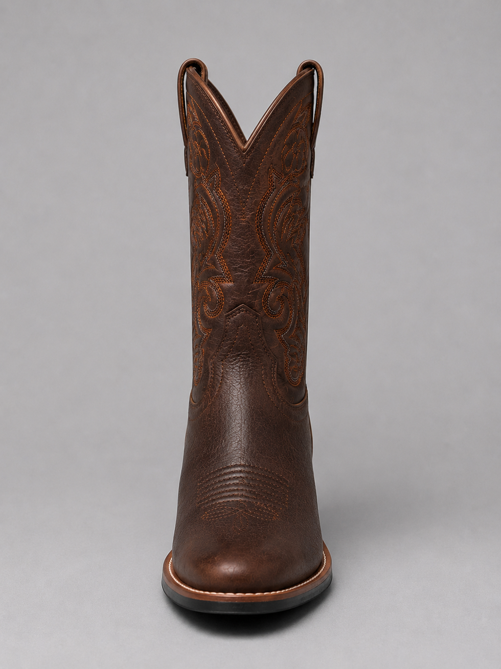 Brown leather cowboy boot with detailed western embroidery, stitched toe, stacked heel