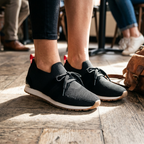 Women's black knit slip-on sneakers with laces and cushioned white sole