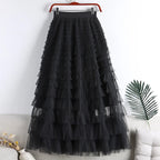 Black tiered tulle maxi skirt with ruffle layers, hanging on a hanger