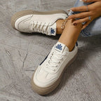 Women’s platform sneakers with white uppers, navy side stripes, and chunky tan sole