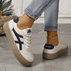 Women’s white platform sneakers with navy side stripes, lace-up, and tan heel platform